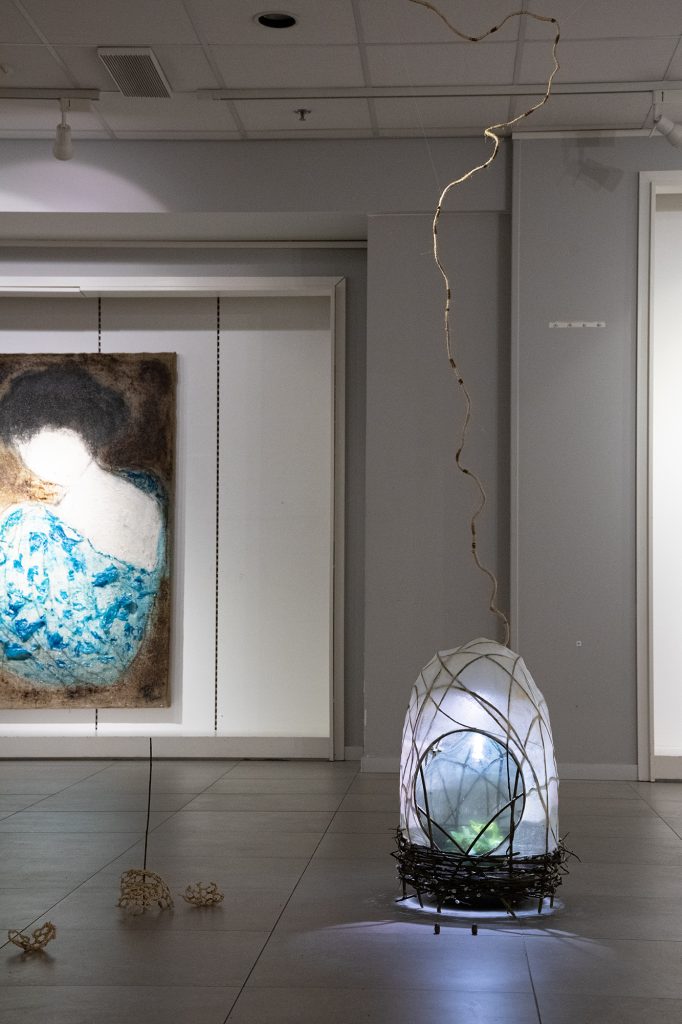 Kevät | installaatio, paju- ja sen kissat, maitoliima, ohuen ohut käsipaperi, pullopuutarha  juoruineen | 47 cm x 66 cm x 50 cm | 2025