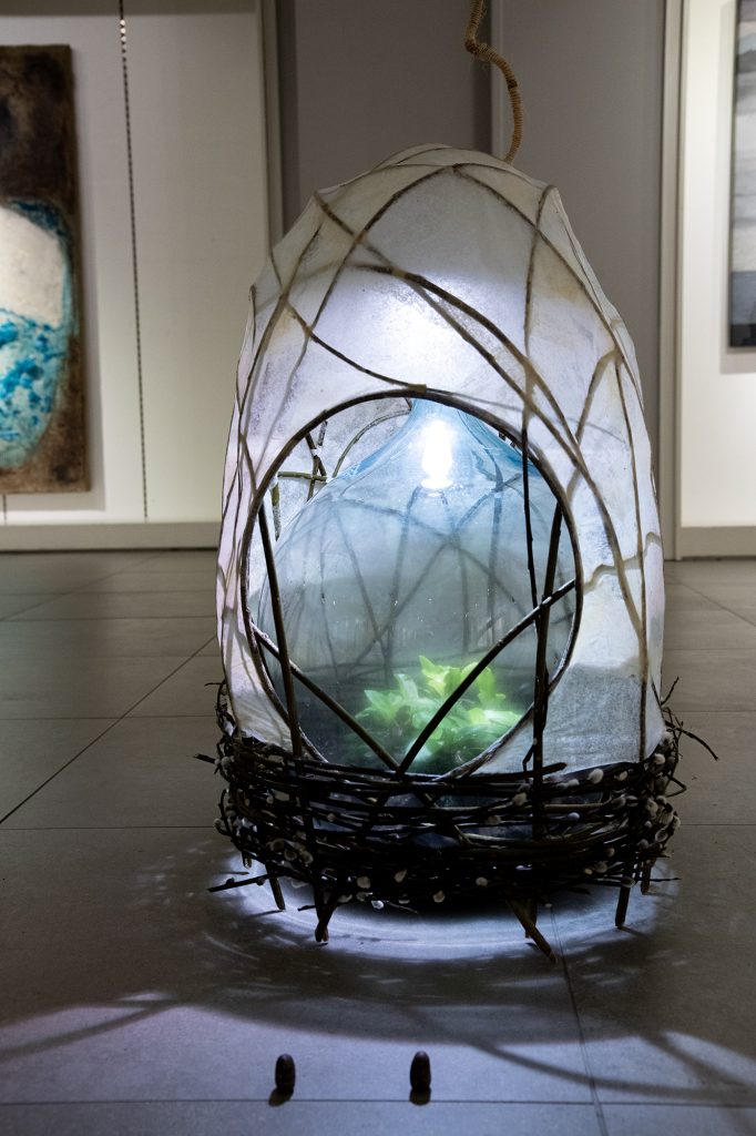 Kevät | installaatio, paju- ja sen kissat, maitoliima, ohuen ohut käsipaperi, pullopuutarha  juoruineen | 47 cm x 66 cm x 50 cm | 2025
